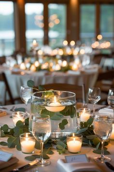 the centerpieces are filled with candles and greenery