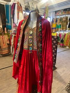 Experience the vibrant charm of our Kuchi 3-Piece Dress!  It's carefully made from the luxurious Bakhmal fabric. The dress is alive with colorful mirror embroidery, giving a playful and lively feel to the classic design. The set includes: Qamees (Shirt): Fashioned from Bakhmal fabric for comfort and opulence. Shalwar (Pants/Trouser): A perfect complement, tailored for ease and elegance. Dupatta (Shawl): Adorned with lively hand embroidery, adding a splash of color and charm. Whether for festive Festive Dabka Kaftan For Festival, Festival Anarkali Style Kaftan With Traditional Drape, Anarkali Style Festival Kaftan With Traditional Drape, Bohemian Sets With Dabka For Festive Occasions, Bohemian Festive Sets With Dabka, Red Bohemian Anarkali Set With Resham Embroidery, Bohemian Red Anarkali Set With Resham Embroidery, Festive Bohemian Anarkali Set With Dabka, Festival Kaftan With Dabka Detailing