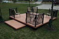 an outdoor deck with chairs and tables in the grass