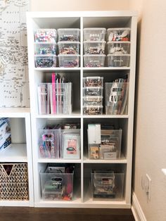 a white bookcase filled with lots of crafting supplies on top of a hard wood floor