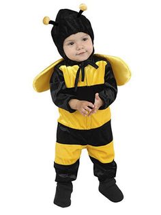 a baby dressed in a bee costume standing with his hands on his hips and looking at the camera