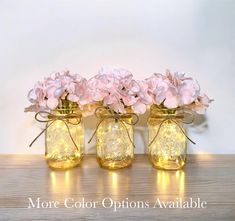 three mason jars with pink flowers in them