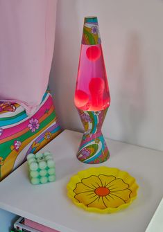 two vases sitting on top of a table next to a yellow and pink object