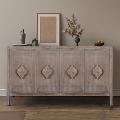 an old wooden cabinet with carvings on the doors and drawers is shown in this living room