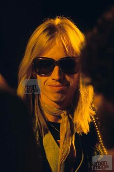 a man with long blonde hair wearing sunglasses