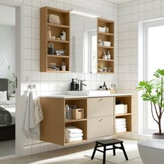 a bathroom with white tile and wooden cabinets