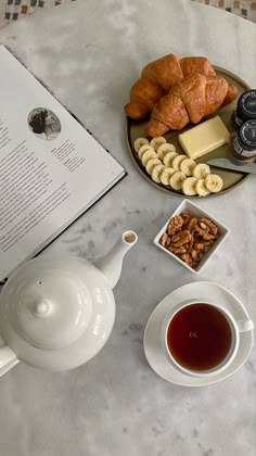 the breakfast is ready to be eaten and served on the table with an open book