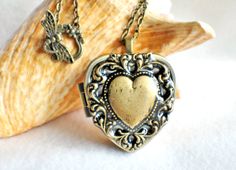 Music box locket, heart locket with music box inside, in bronze with lacey edge floral heart on cover. Elegant Heart Necklace With Vintage Charm As Gift, Vintage Heart-shaped Brass Jewelry, Elegant Brass Locket Necklace For Valentine's Day, Vintage Brass Heart-shaped Jewelry, Vintage Brass Heart Shaped Jewelry, Vintage Bronze Heart Pendant Necklace, Handmade Vintage Heart Necklace, Vintage Bronze Necklaces For Valentine's Day, Elegant Vintage Charm Locket Necklace For Valentine's Day