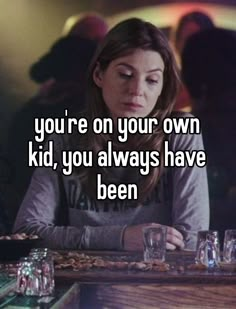 a woman sitting at a table with the words you're on your own kid, you