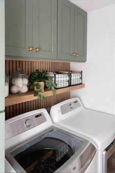 a washer and dryer in a room with green cupboards on the wall