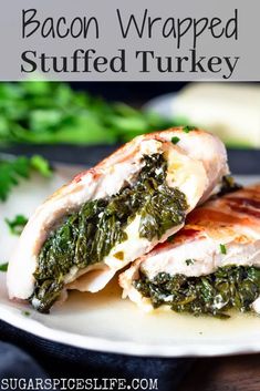 bacon wrapped stuffed turkey with spinach on a white plate and green garnish