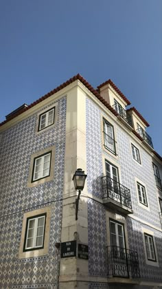 a tall building with blue and white tiles on it's side, next to a street light