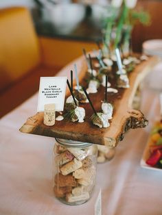 a wooden table topped with jars filled with small candies and marshmallows