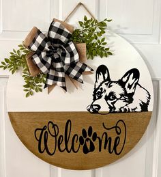 a welcome sign hanging on the front door with a dog's paw and name