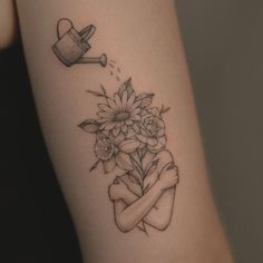 a woman's arm with flowers and watering can tattoo on the left side of her body