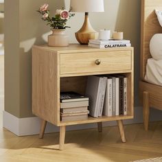 a nightstand with books and flowers on it