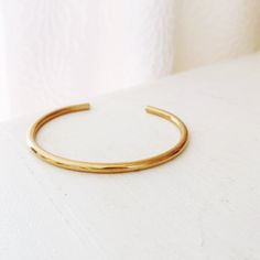 A thick cuff to capture the sun's light and shine from every angle. Wear alone or stack a couple for a pretty chime. Sold individually. Slightly adjustable for the perfect fit. Available in 14k USA Gold-filled or USA brass Gold-filled is tarnish resistant and will not need to be polished regularly. Brass can tarnish under certain conditions but can always be returned to its original shine with a polishing cloth. Neither metal types will fade, flake, or peel with wear. If you choose brass, we rec Classic Adjustable Gold Brass Bracelet, Minimalist Yellow Gold Brass Cuff Bracelet, Adjustable Stackable Brass Cuff Bracelet, Adjustable Yellow Gold Round Cuff Bracelet, Adjustable Yellow Gold Open Cuff Jewelry, Adjustable Tarnish Resistant Bangle, Minimalist Everyday Brass Bangle, Everyday Minimalist Brass Bangle, Minimalist Adjustable Brass Cuff Bracelet