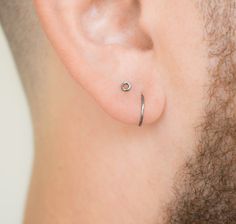 a close up of a man's ear with a nose ring attached to it