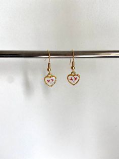 These stunning earrings are the perfect accessory to complete any outfit, and they are sure to make you look and feel your very best! Each earring features two delicate, real pressed flowers preserved in clear resin inside of a small, gold heart charm. You can choose from 24k gold plated wire (comes with rubber earring back), 24k gold plated leverback (huggies), or clip on earrings (no piercing needed). If you would like a combination of flower colors, please specify in the personalization box w Earrings No Piercing, Earrings Huggies, Flower Colors, Heart Flower, Etsy Bridesmaid Gifts, Heart Drop Earrings, Resin Earrings, Clear Resin, Stunning Earrings