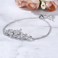 Surround her with flowers all year long. Buy that special someone this silver flower bracelet, whether she is celebrating a holiday or if she is just a lover of flowers. Crafted in sterling silver, the bracelet consists from cluster flowers at the center on a classic cross chain, which shows elegance and sparkle. The bolo bracelet is easy to adjust the size to fit for her wrist to create different looks. Surprised her with this charming piece.Carat Weight: 1.74 ctStone Size: 1.3,1.5,1.7,2,2.5,3 Flower-shaped Cubic Zirconia Bracelets As Gift, Elegant Sterling Silver Flower Bracelets, Elegant Silver Bracelets With Flower Shape, Elegant Silver Bracelets In Flower Shape, Delicate Silver Bracelet For Anniversary, Elegant Silver Flower-shaped Bracelets, Flower Shaped Cubic Zirconia Bracelets As Gift, Flower-shaped Cubic Zirconia Bracelets For Gifts, Flower-shaped Cubic Zirconia Bracelet For Gifting