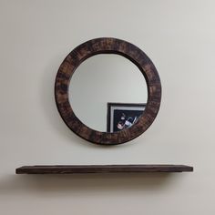 a wooden shelf with a round mirror on it