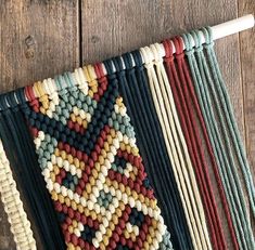 a close up of a piece of cloth on a wooden floor with knitting needles in the background