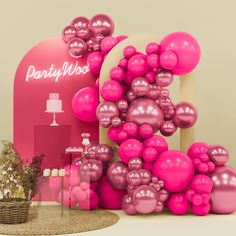 pink balloons are on display in front of a party booth