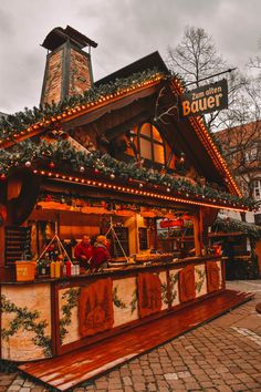 an outdoor bar with christmas decorations on the roof and lights hanging from it's roof