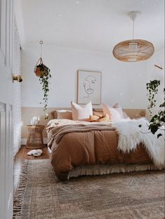 a bedroom with a bed, plants and pictures on the wall