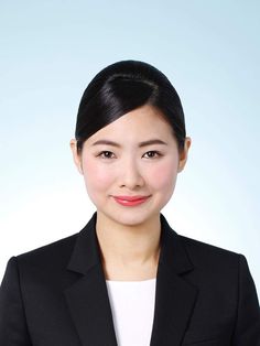 a woman in a black suit and white shirt smiling at the camera with her arms crossed