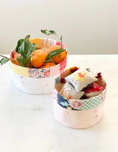 two bowls filled with fruit sitting on top of a white table next to each other