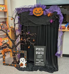 halloween decorations are displayed in front of a black drapes with purple and orange ribbons