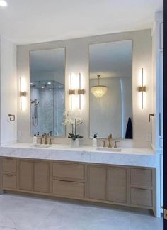 a bathroom with two sinks and three mirrors