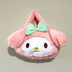 a pink and white stuffed animal with a bow on it's head that is attached to a wall