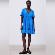 Dress With V-Neck And Turned-Up Short Sleeves. Flounced Hem.False Jewel Buttons At Front, Armpit To Armpit 21”, Length 35”. Brand New With Tags. Color Is Close To Model Pic Summer V-neck Tiered Dress For Daywear, Casual Blue Flowy V-neck Dress, Blue V-neck Dress For Summer Daywear, Summer Tiered Dress With Ruffle Hem And V-neck, Casual V-neck Tiered Dress For Beach, V-neck Tiered Beach Dress With Ruffle Hem, Beach V-neck Tiered Dress With Ruffle Hem, Summer V-neck Tiered Dress, Blue Mini-length Tiered Dress For Brunch