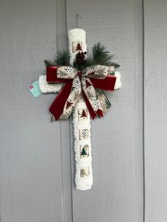 a cross made out of toilet paper with christmas decorations hanging on the side of it