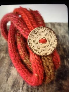 red and brown yarn with a wooden button on it