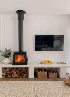 a living room with a fire place and television mounted on the white wall behind it