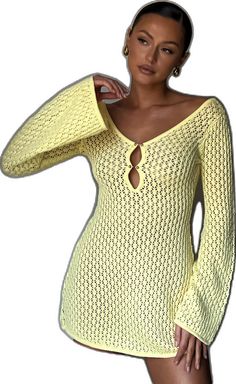 a woman wearing a yellow knitted dress with long sleeves and an open neckline