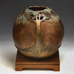 a brown vase sitting on top of a wooden stand