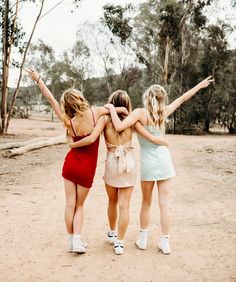 three girls in dresses are standing together and hugging each other with their arms around one another