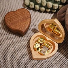 a wooden heart shaped music box sitting on top of a table next to a stuffed animal