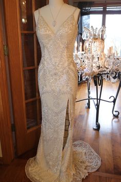 a wedding dress on display in front of a chandelier