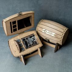 two wooden boxes that are open and sitting on the ground, one with three different items in it