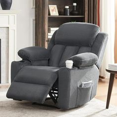 a gray recliner chair sitting in front of a fireplace