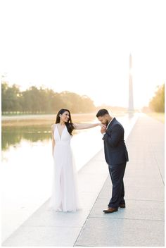 a man and woman standing next to each other near the washington monument