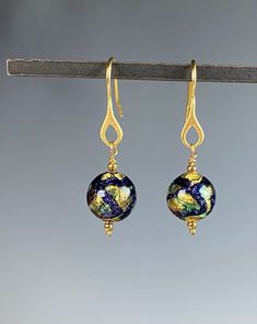 "Romantic and sultry Murano glass earrings that will captivate you! These artisan made glass beads from Murano, Italy are doused with colors of blue and green with genuine 18k gold foil within each bead! The beads hang on Vermeil gold ear wires. They hang 1.5 inches. A wonderful gift for any occasion and arrives in a standard gift box. ✨ Authentic Murano Glass: Each pair of earrings showcases the unparalleled beauty of Murano glass, renowned for its vibrant colors and intricate patterns. See our Elegant Glass Drop Earrings, Elegant Glass Dangle Jewelry, Elegant Dangle Glass Jewelry, Formal Gold Glass Earrings, Elegant Gold Glass Earrings, Elegant Glass Dangle Earrings, Glass Drop Earrings For Formal Occasions, Elegant Nickel Free Glass Earrings, Elegant Nickel-free Glass Earrings