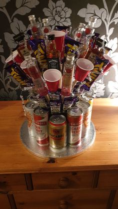 an arrangement of liquor bottles and cans on a table