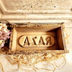 an old wooden box with the word raza carved into it and some dried flowers