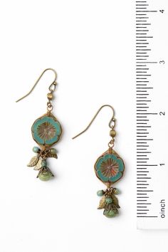 These handcrafted earrings are longer in design with a stunning Czech glass flower focal that has been hand wrapped in our signature herringbone weave with antique brass leaves and dangles of Czech glass. They are completed with antique brass ear wires and hang at approximately 2.5" in length. Antique Brass (lead and nickel free) Czech Glass 2.5", with antique brass ear wires We hand select our natural materials, thus there may be slight variations in color and/or size that will not detract from Bohemian Czech Glass Dangle Flower Earrings, Handmade Bohemian Flower Earrings With Czech Glass, Vintage Handmade Brass Beaded Earrings, Handmade Vintage Brass Beaded Earrings, Handmade Dangle Brass Flower Earrings, Handmade Brass Dangle Flower Earrings, Bohemian Brass Drop Flower Earrings, Bohemian Brass Dangle Flower Earrings, Bohemian Brass Flower Jewelry